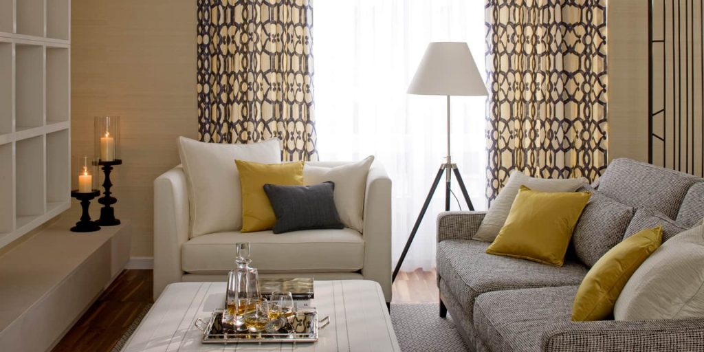 modern living room in neutral colour palette of grey, which and gold