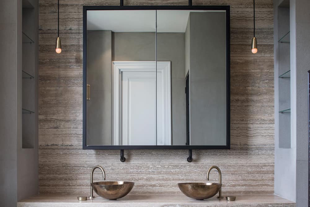the focal point of this contemporary bathroom is the vanity area constructed in ocean black honed travertine and urban grey antiqued limestone