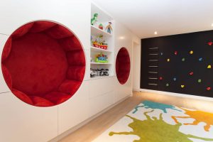 children's playroom with built-in circular seating and a climbing wall built onto a wall of black chalkboard paint