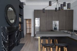 modern industrial kitchen with brown timber kitchen island and marble fireplace