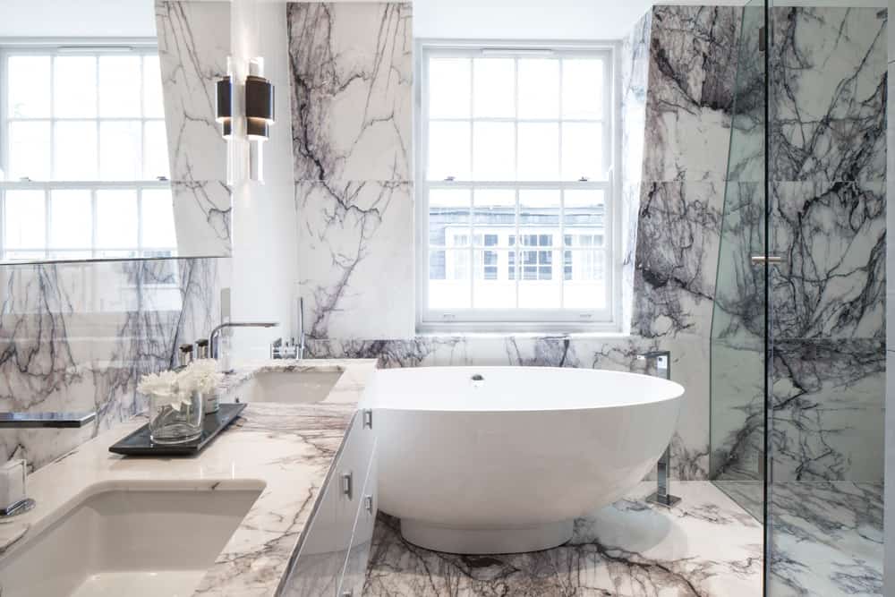 hotel luxury white bathroom with Turkish lilac marble and round freestanding bath by roselind wilson design