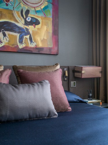 hotel luxury bedroom with antique brass bedside light and colourful, contemporary artwork designed by roselind wilson design