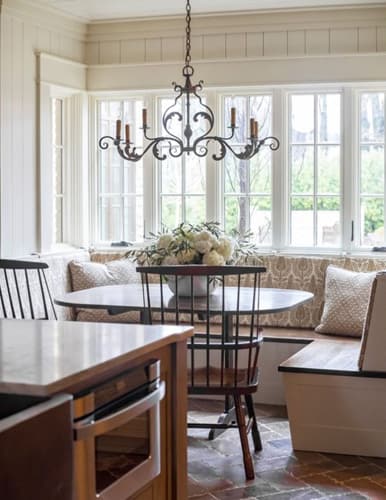 Breakfast nook in a neutral colour palette, wood panelling and delicate patterns.