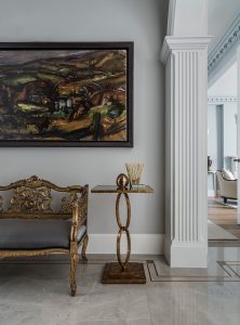 entrance hallway with decorative bench and gold leaf side table