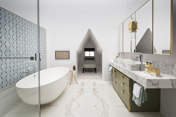 Luxurious bathroom with oval freestanding bath, alcove with daybed, marble bookmatched flooring and bespoke marble bathroom vanity unit