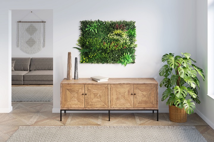 Faux plant display on the wall with faux monstera in the corner of the room