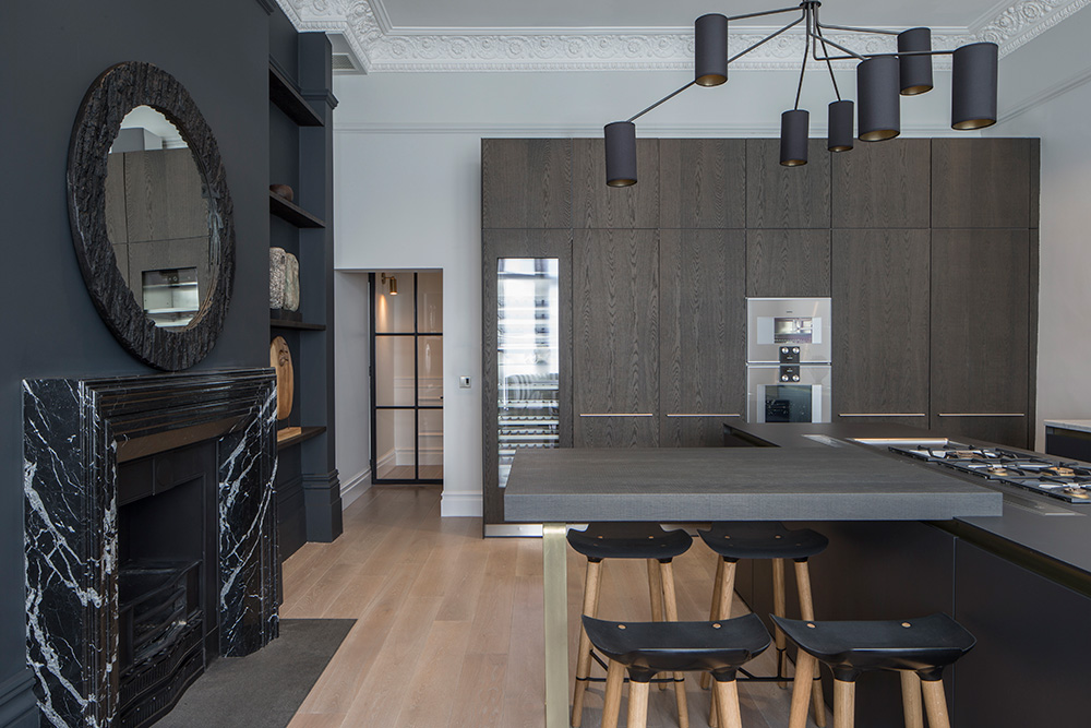 contemporary kitchen with dark grey wall and marble fireplace