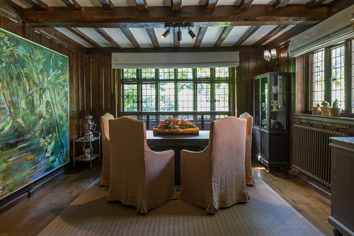 cosy mock-Tudor dining room with rustic chair covers and exposed beams
