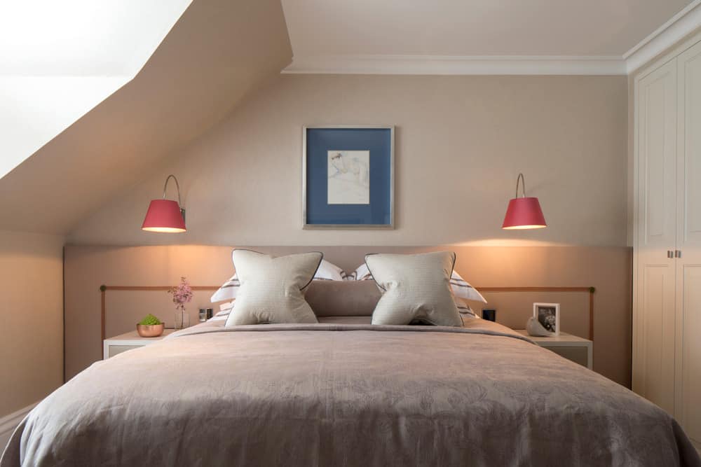luxurious bedroom with pink wall lights and a full width headboard