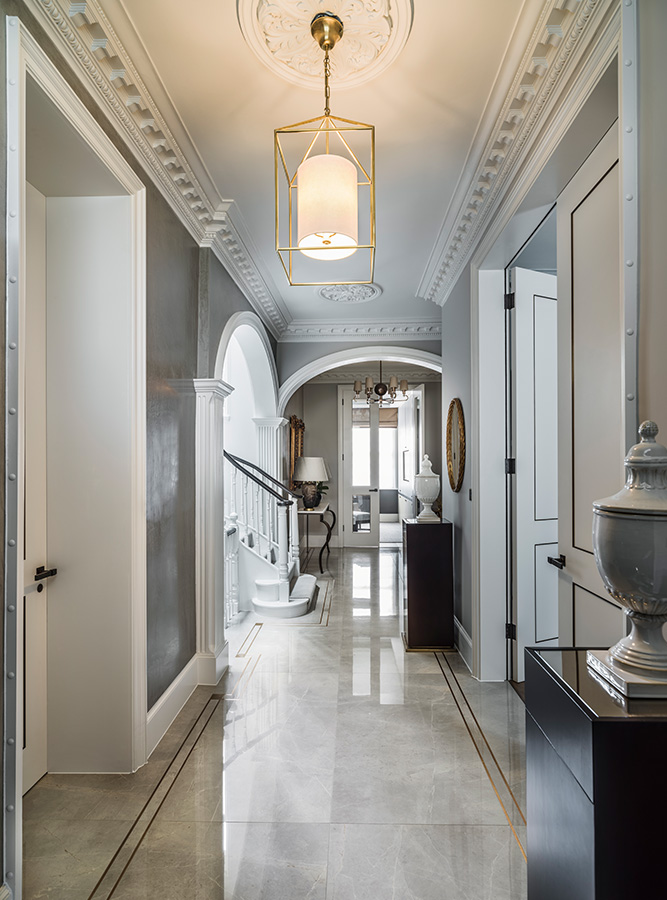 luxury entrance hallway flooring with bronze tramlines and pendant chandelier