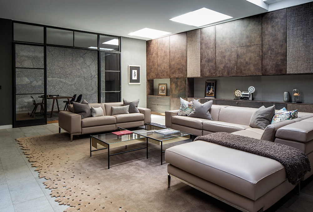 An entertaining room with taupe sofas and brown cupboards
