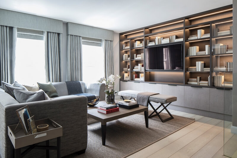 Contemporary grey living room with bespoke joinery shelving and grey L-shaped sofa