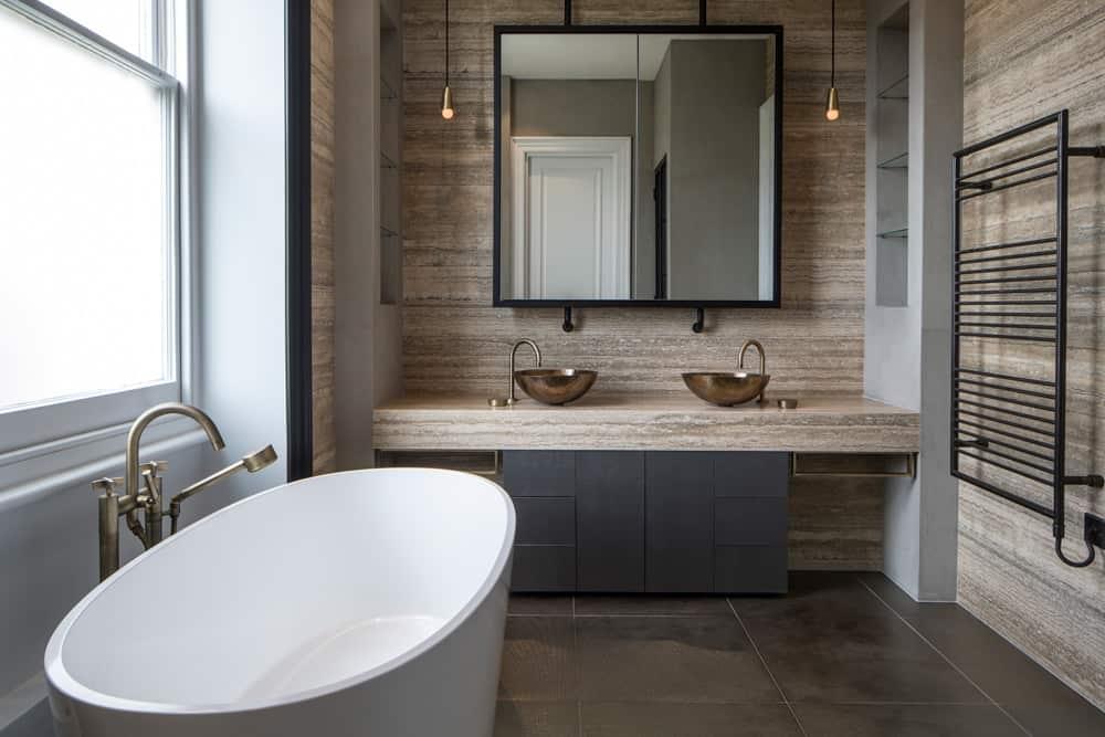 hotel luxury bathroom with striped marble bathroom vanity, hammered bronze basins and white oval freestanding bath by roselind wilson design